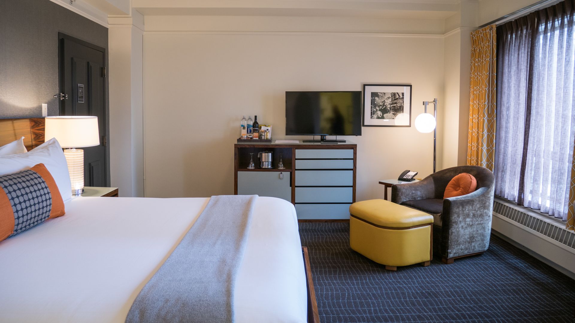 A Bedroom With A Bed And Desk In A Hotel Room