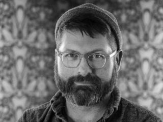 Colin Meloy Wearing Glasses And Looking At The Camera